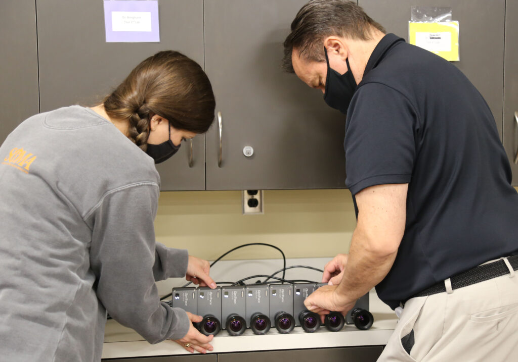 student and professor adjust motion capture cameras