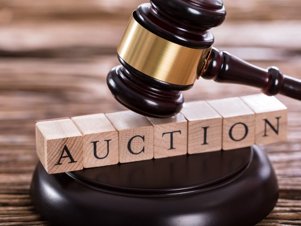 Photo of gavel posed over word auction using Scrabble tiles