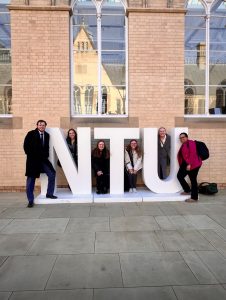 Photo of law student Erica Howard '26 and other students pose in front of Nottingham Trent University sign