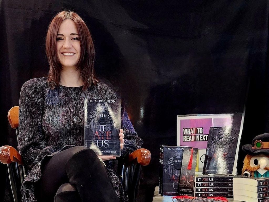 Photo of Melanie Robinson '28 holding her book, 