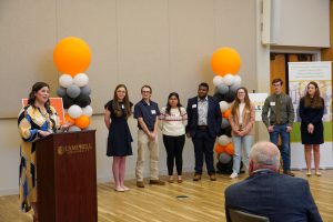 Golden LEAF Scholars watching alumni Emily Drake '17 speaking at Golden LEAF Scholar Luncheon