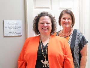 Crystal Dowless posing with April Gonang next to Crystal's plaque