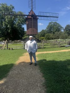 Quan standing in front of a windmill in costume.