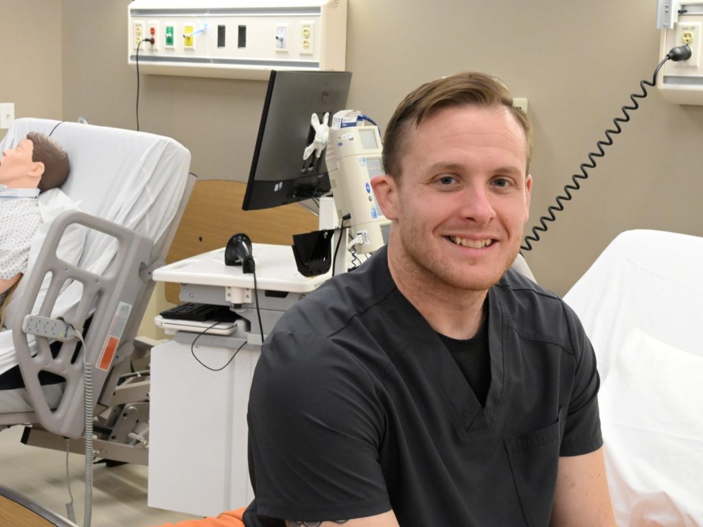 Christopher Donovan sitting in nursing lab