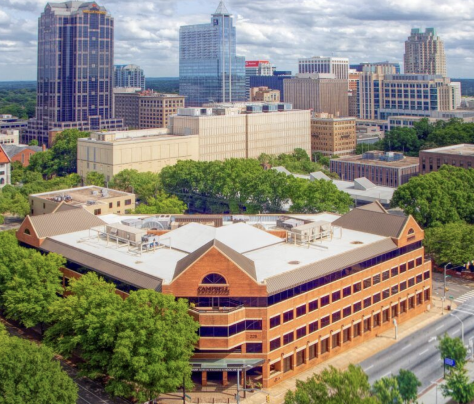 Photo of law school building with Raleigh city scape behind it